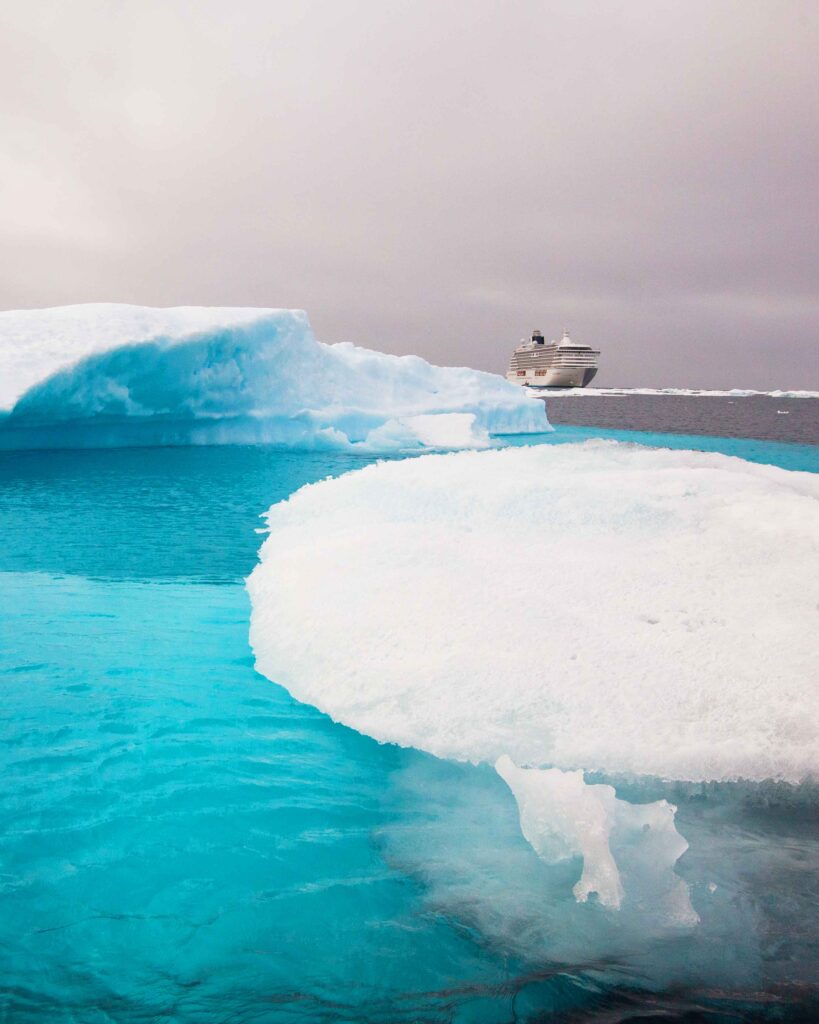 Crystal Serenity triumphs through the Arctic's icy expanse: A majestic sight as the ship navigates resiliently, breaking through the frozen barriers on its journey through the Northwest Passage.