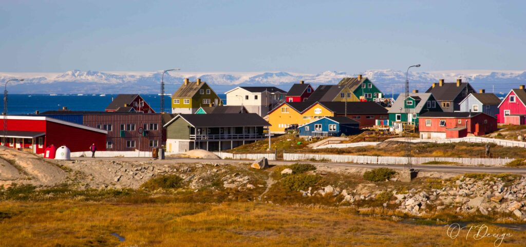 Capturing the vibrant charm of Ilulissat: Colorful houses set against the Arctic backdrop, creating a picturesque scene in this Greenlandic coastal town.